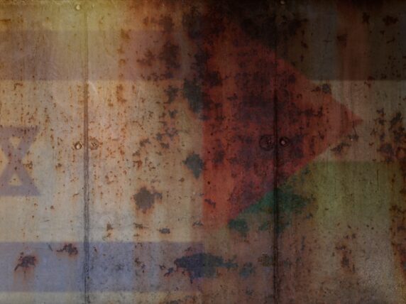 Two flags against a concrete wall