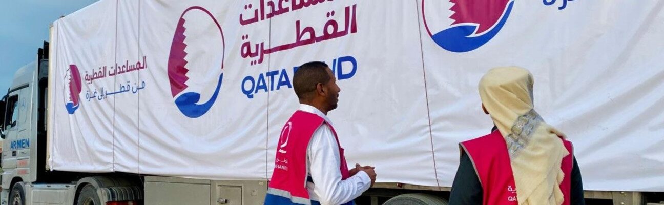 Qatar Charity aid workers loading one of the land-bridge trucks.