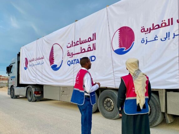 Qatar Charity aid workers loading one of the land-bridge trucks.